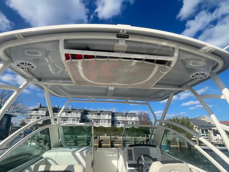 Slide: The Image of 2023 Sailfish 245 DC boat interior with hardtop, clear sky, and waterfront view. - 45