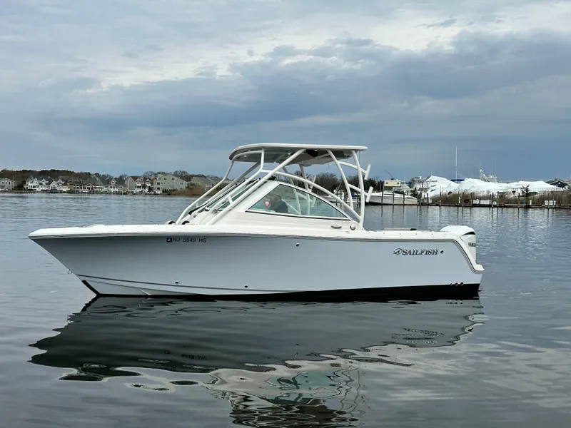 Slide: The Image of 2023 Sailfish 245 DC boat on calm water under cloudy sky. - 5