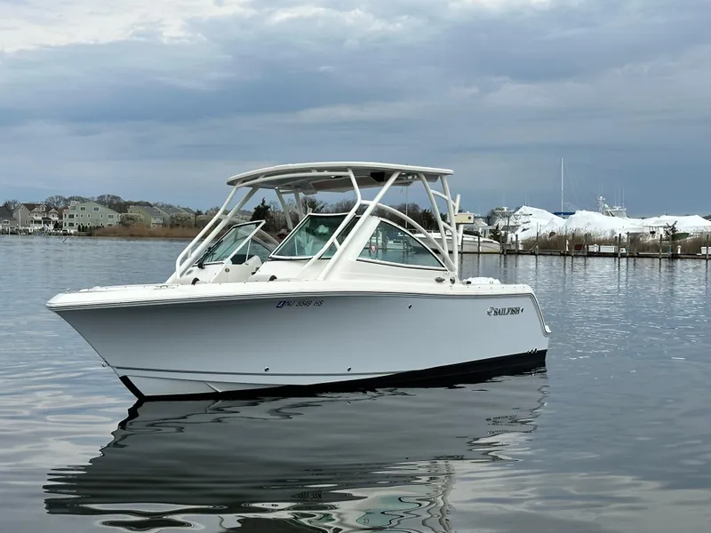 Slide: The Image of 2023 Sailfish 245 DC boat on calm water with cloudy sky background. - 7