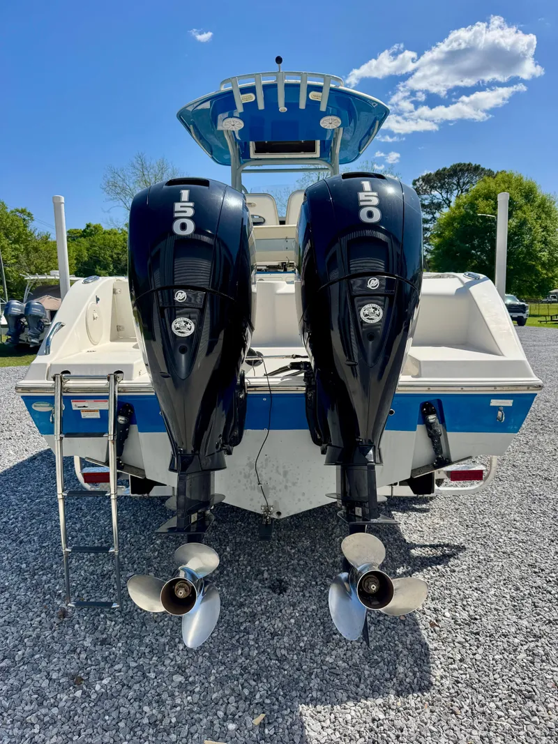Slide: The Image of 2019 Cobia 261 boat with dual 150 horsepower engines, parked on gravel. - 5