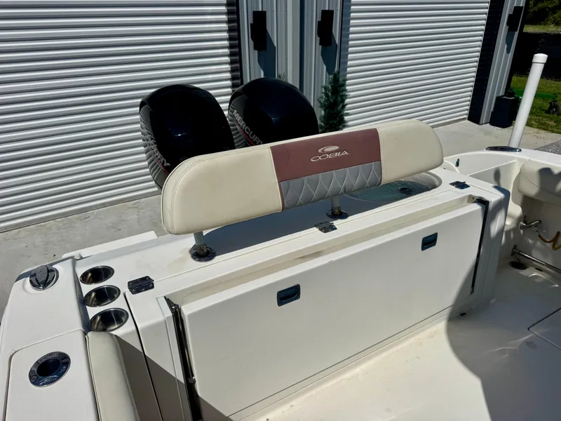 Slide: The Image of 2019 Cobia 261 boat with dual engines and cushioned seating near storage area. - 9