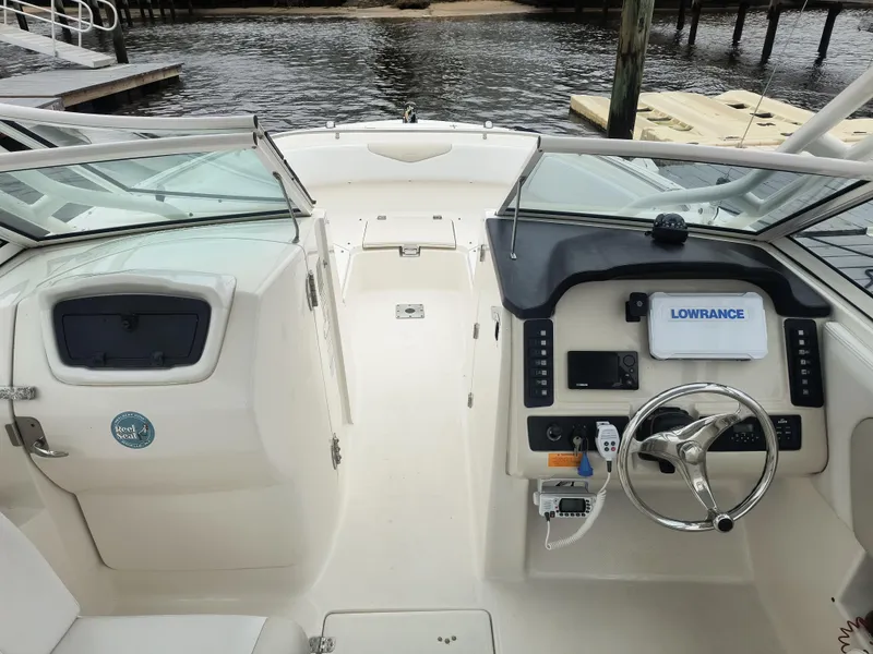 Slide: The Image of 2016 Robalo R247 Dual Console boat interior with steering wheel and Lowrance navigation system. - 11