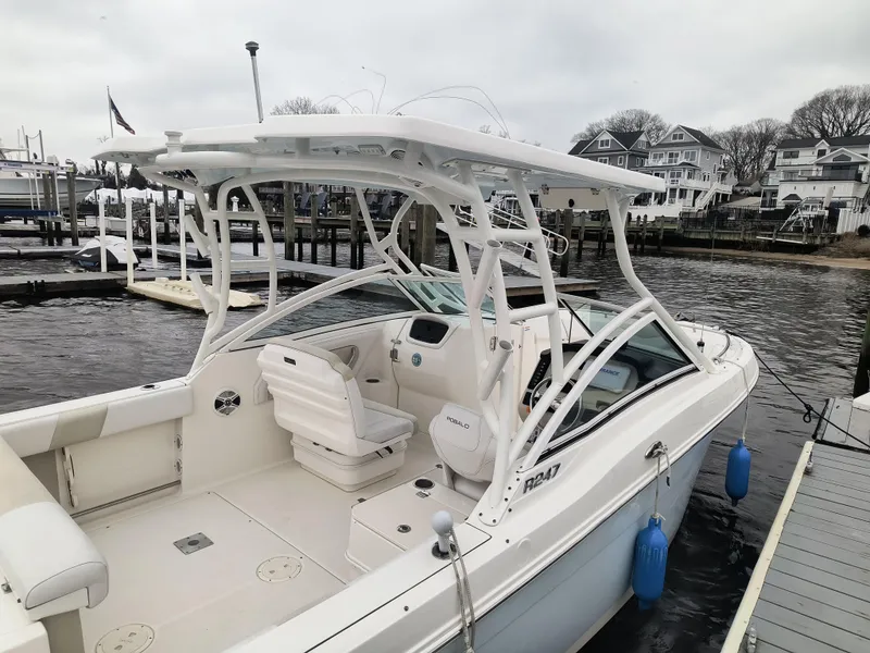 Slide: The Image of 2016 Robalo R247 Dual Console boat docked at marina, featuring spacious seating and sleek design. - 12