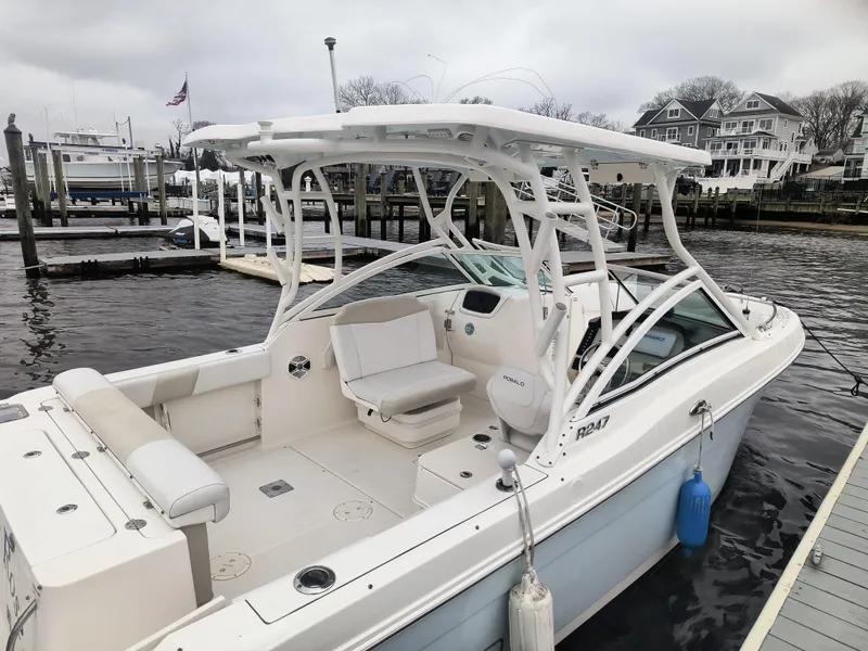 Slide: The Image of 2016 Robalo R247 Dual Console boat docked at marina, featuring spacious seating and sleek design. - 3