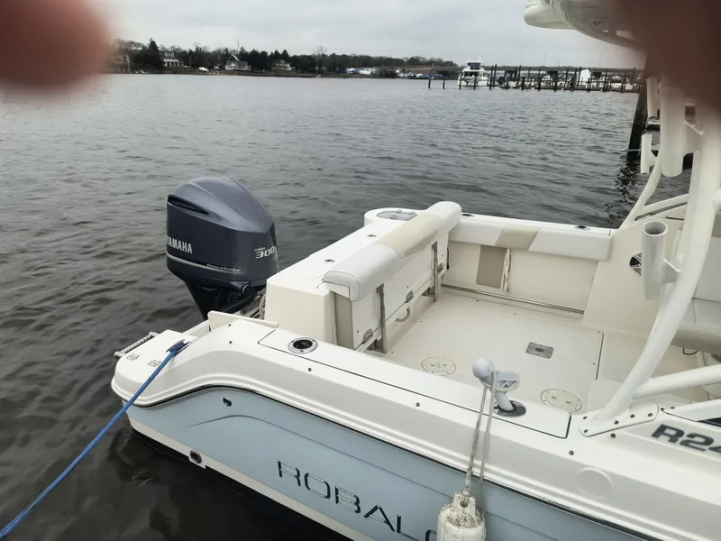 Slide: The Image of 2016 Robalo R247 Dual Console boat with Yamaha engine docked on calm water. - 4