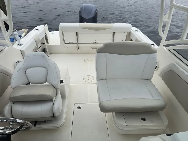 Slide: The Image of 2016 Robalo R247 Dual Console boat interior with white seating and open deck. - 8