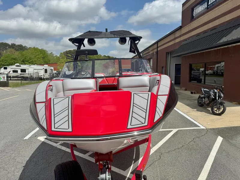 Slide: The Image of 2021 Moomba Mojo boat with red and gray design, parked outside a Yamaha dealership. - 4