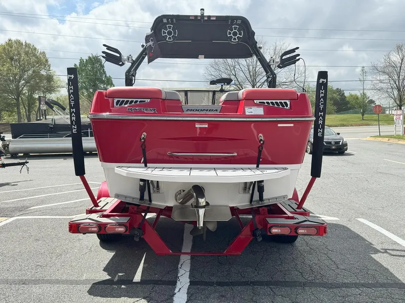 Slide: The Image of 2021 Moomba Mojo boat, red, rear view in parking lot, with wakeboard tower and trailer. - 6