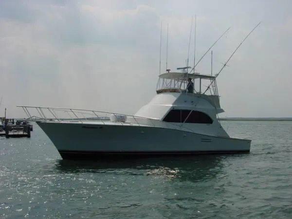 The Image of 1984 Post Convertible yacht on water, great deal, sleek design, fishing rods visible. - 0