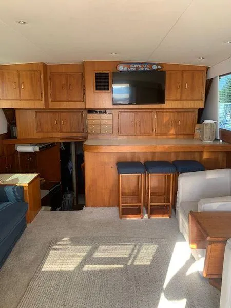 Slide: The Image of 1984 Post Convertible interior with wooden cabinets, bar stools, and a cozy seating area. - 14