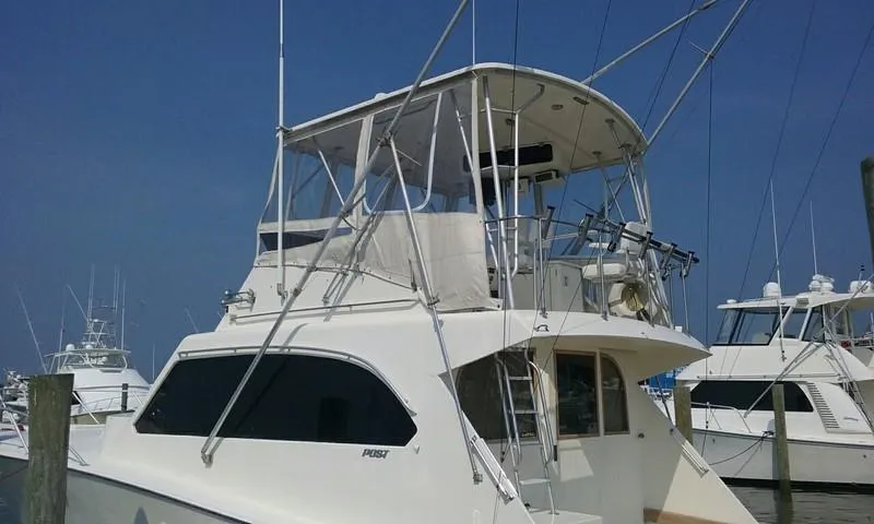 Slide: The Image of 1984 Post Convertible boat docked, featuring a spacious upper deck and sleek design. - 2