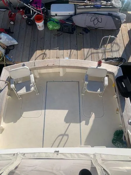 Slide: The Image of 1984 Post Convertible boat deck with chairs, docked with equipment nearby. - 4