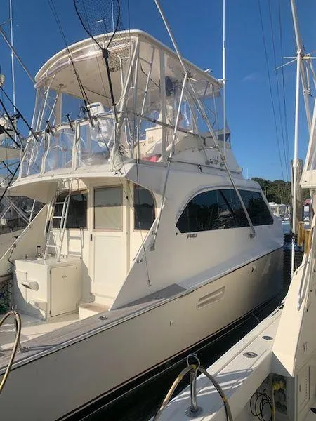 Slide: The Image of 1984 Post Convertible yacht docked, showcasing sleek design and spacious upper deck. - 5