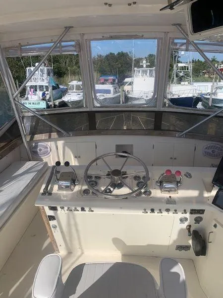 Slide: The Image of 1984 Post Convertible boat cockpit with steering wheel, controls, and marina view. Great deal! - 6