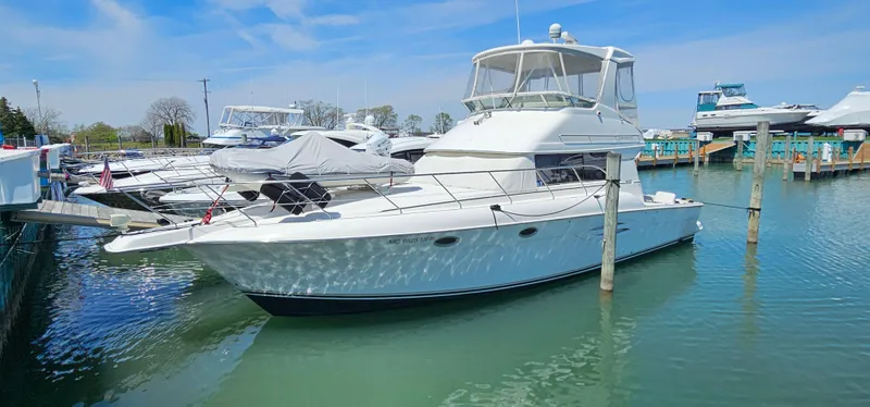 Slide: The Image of 2003 Silverton 42 Convertible yacht docked in a marina under a clear blue sky. - 1