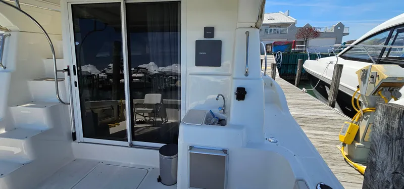 Slide: The Image of 2003 Silverton 42 Convertible yacht docked, featuring a spacious deck and sliding glass doors. - 10