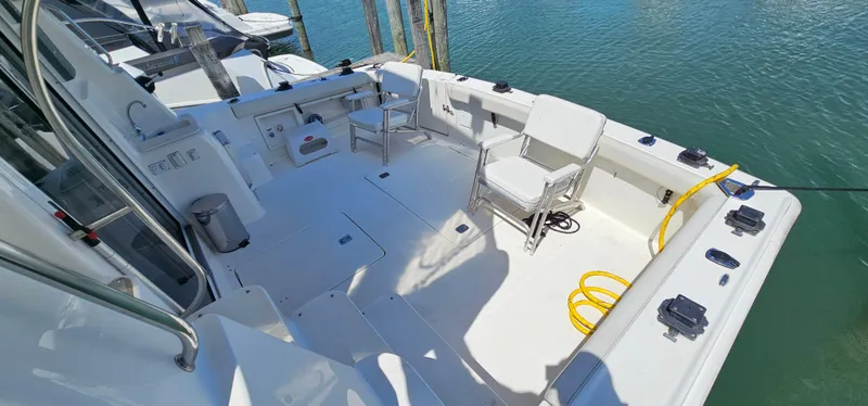 Slide: The Image of 2003 Silverton 42 Convertible yacht deck with seating, docked by the water. - 13