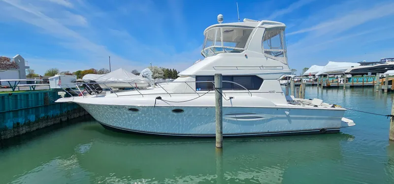 Slide: The Image of 2003 Silverton 42 Convertible yacht docked in a marina under a clear blue sky. - 2