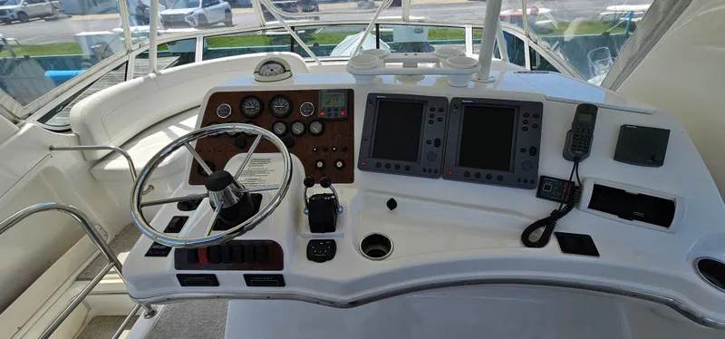 Slide: The Image of 2003 Silverton 42 Convertible yacht helm with steering wheel, gauges, and navigation equipment. - 21
