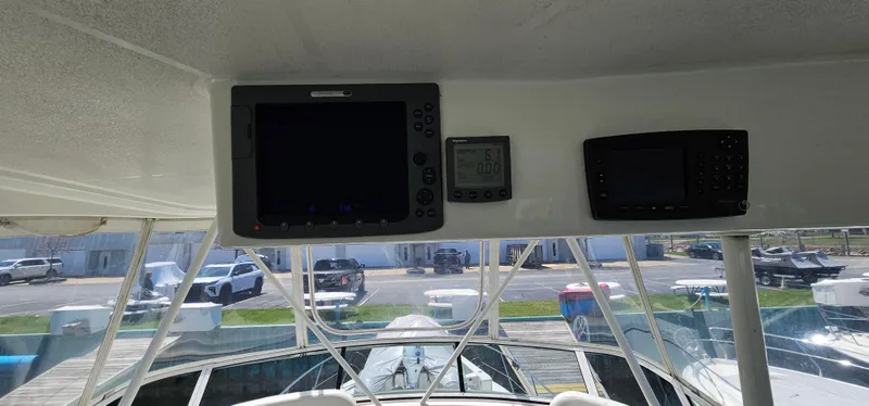 Slide: The Image of 2003 Silverton 42 Convertible boat dashboard with navigation equipment and marina view. - 24