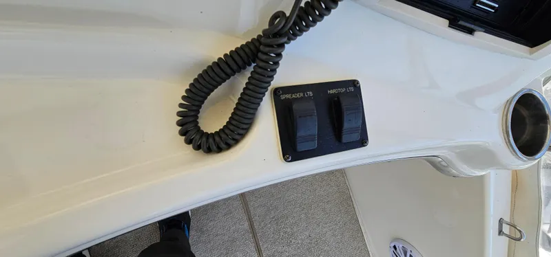 Slide: The Image of Control panel on a 2003 Silverton 42 Convertible boat with switches and coiled cable. - 26