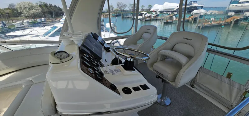 Slide: The Image of 2003 Silverton 42 Convertible yacht helm with plush seating and marina view. - 27