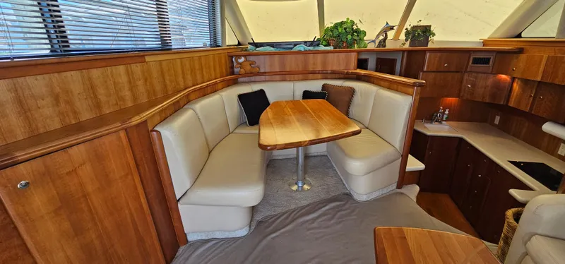 Slide: The Image of Interior of 2003 Silverton 42 Convertible yacht with wood finish and cozy seating area. - 29