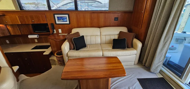 Slide: The Image of Interior of 2003 Silverton 42 Convertible yacht with sofa and wooden table. - 32