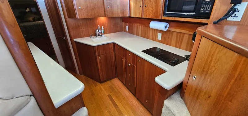 Slide: The Image of 2003 Silverton 42 Convertible yacht kitchen with wood cabinetry and modern appliances. - 33