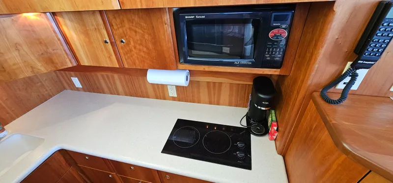 Slide: The Image of 2003 Silverton 42 Convertible kitchen with microwave, stovetop, and wooden cabinetry. - 34