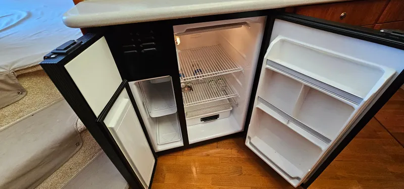 Slide: The Image of Open refrigerator inside 2003 Silverton 42 Convertible yacht, showing shelves and storage space. - 36