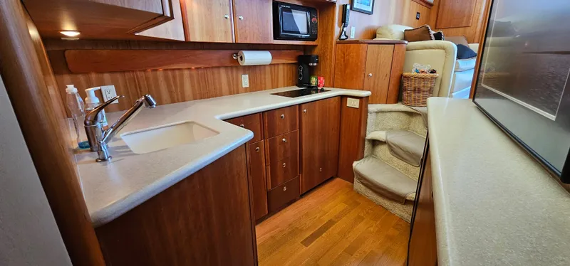 Slide: The Image of 2003 Silverton 42 Convertible yacht interior with modern kitchen and wooden cabinetry. - 37