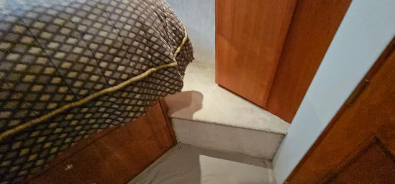 Slide: The Image of Interior of 2003 Silverton 42 Convertible yacht, featuring a cozy bedroom with wooden cabinetry. - 41