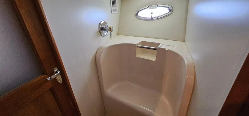 Slide: The Image of Shower area in 2003 Silverton 42 Convertible yacht with oval window and wooden door. - 42