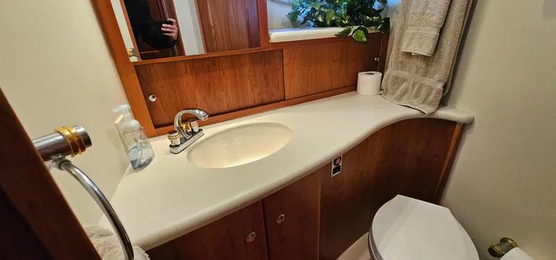 Slide: The Image of 2003 Silverton 42 Convertible yacht bathroom with sink, mirror, and toilet. - 43