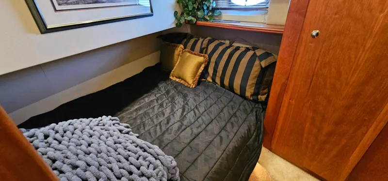 Slide: The Image of Cozy bedroom in 2003 Silverton 42 Convertible yacht with striped bedding and decorative pillows. - 45