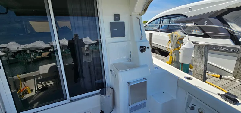 Slide: The Image of 2003 Silverton 42 Convertible yacht interior with sink and docked boat view. - 48