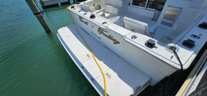 Slide: The Image of 2003 Silverton 42 Convertible yacht docked, featuring spacious deck and clean white finish. - 6