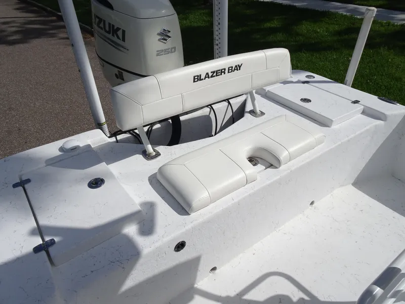 Slide: The Image of 2019 Blazer Bay 2400 boat interior with Suzuki engine, white seating, and storage compartments. - 15