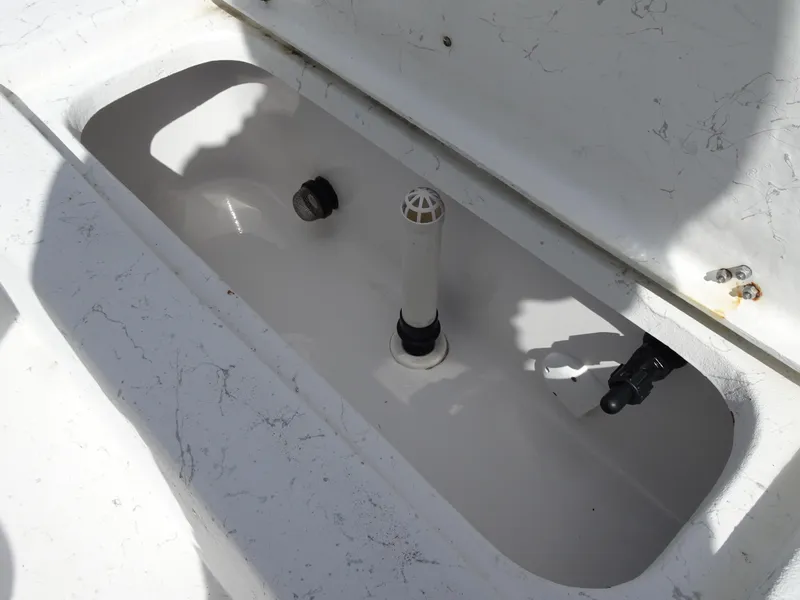 Slide: The Image of Livewell compartment in a 2019 Blazer Bay 2400 boat, featuring plumbing and drainage components. - 23