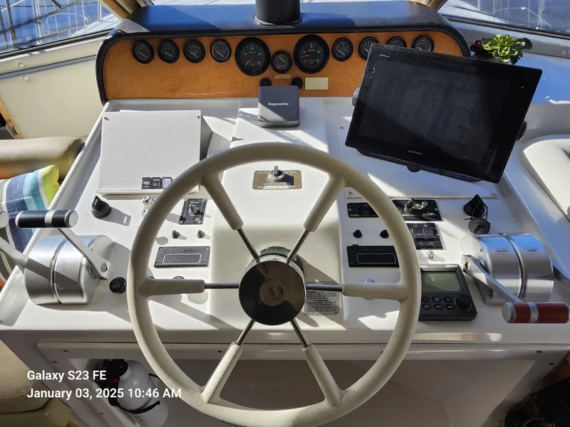 Slide: The Image of Navigator 4800 CLASSIC 1999 yacht helm with steering wheel, control panel, and seating area. - 14