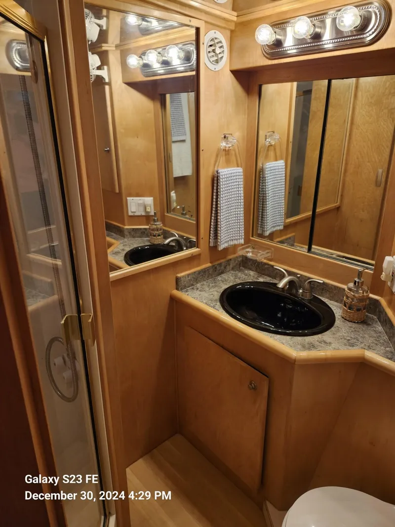 Slide: The Image of Interior of 1999 Navigator 4800 CLASSIC with open cabinets and seashell-patterned bedding. - 23
