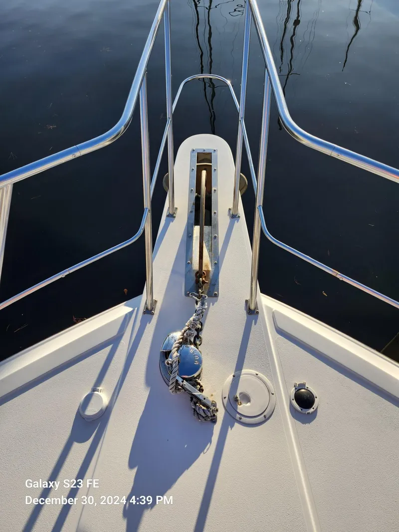 Slide: The Image of 1999 Navigator 4800 CLASSIC yacht docked in a marina, surrounded by other boats. - 30