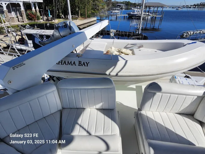 Slide: The Image of Luxurious 1999 Navigator 4800 CLASSIC yacht interior with white seating, docked by serene waters. - 37