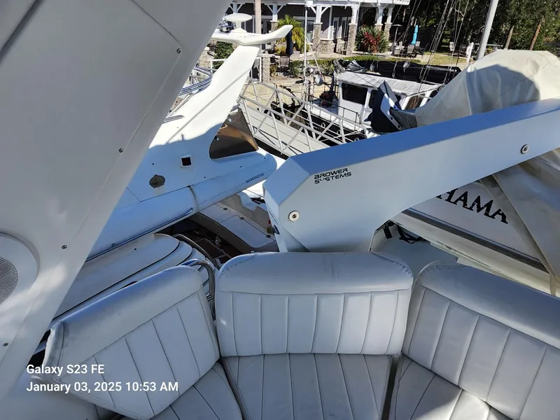 Slide: The Image of Navigator 4800 CLASSIC yacht with white seating and a small boat, docked by the water. - 39