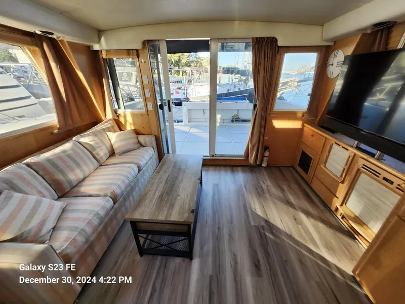 Slide: The Image of 1999 Navigator 4800 CLASSIC yacht docked, featuring upper deck and tender boat. - 4