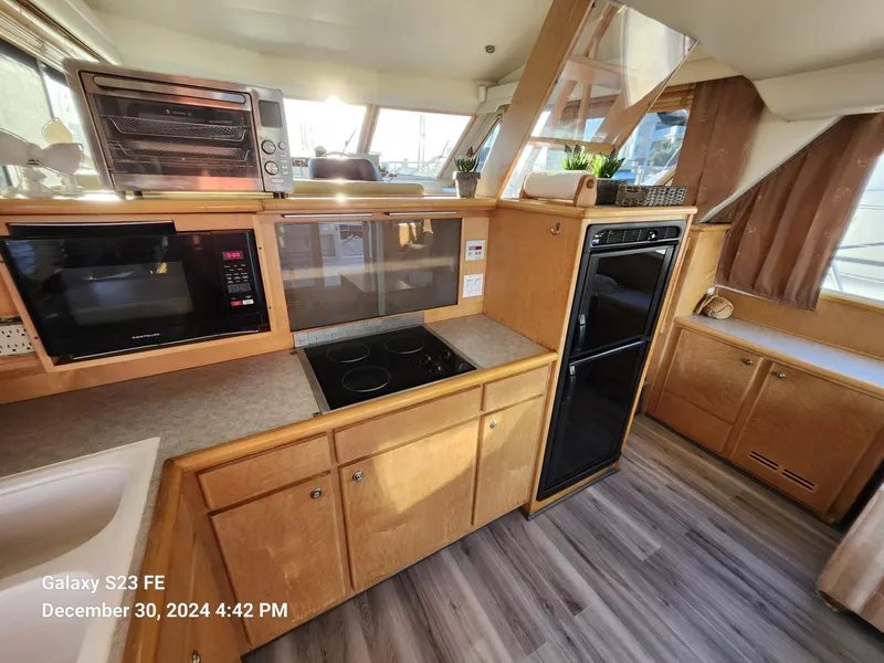 Slide: The Image of Interior of 1999 Navigator 4800 CLASSIC yacht with sofa, table, and kitchen area. - 8