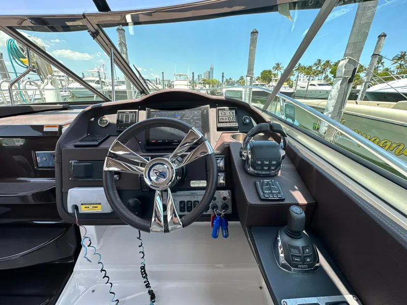 Slide: The Image of Cockpit of 2015 Regal 32 Express boat with steering wheel and control panel. - 11