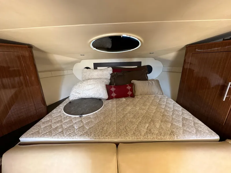 Slide: The Image of Interior cabin of 2015 Regal 32 Express with cozy bedding and wooden cabinets. - 16