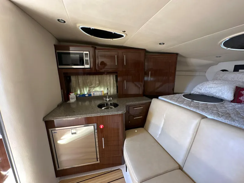 Slide: The Image of 2015 Regal 32 Express interior with kitchenette, microwave, and seating area. - 17